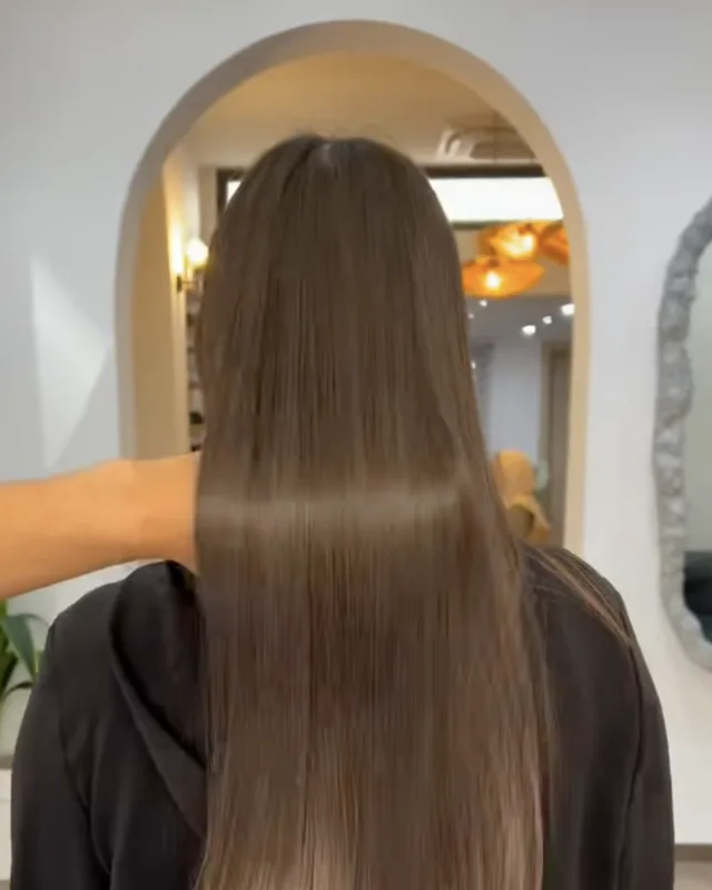 Lissage sur cheveux longs, vu de dos dans le salon