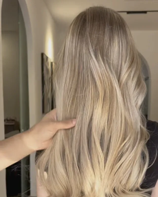 Blond long travaillé en balayage, vu de dos dans le salon