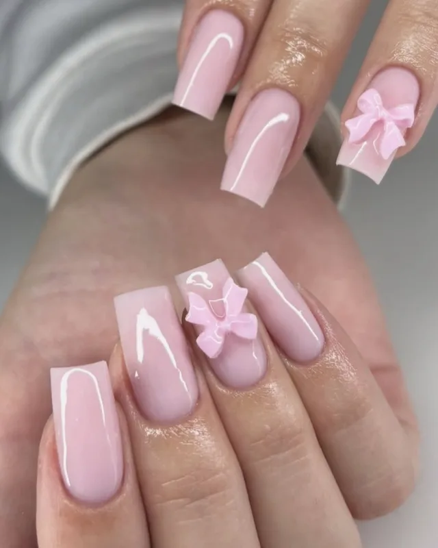 Pose d'ongles roses avec des noeuds en relief